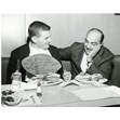 Canadian football player Dick Shatto and Lou Agasee at Shopsy's Restaurant seated at a table with two deli sandwiches, Spadina Ave., Toronto, 26 October 1961. Ontario Jewish Archives, Blankenstein Family Heritage Centre, item 5023.|